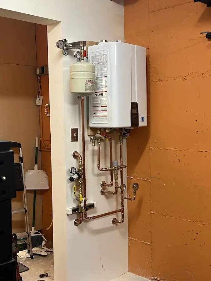 Plumbing technician inspecting water heater connections in Marlow Heights